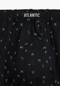 Czarne bawełniane bokserki z zielonymi wzorami liści i białymi kropkami. Elastyczny pasek w talii z nazwą marki "ATLANTIC."