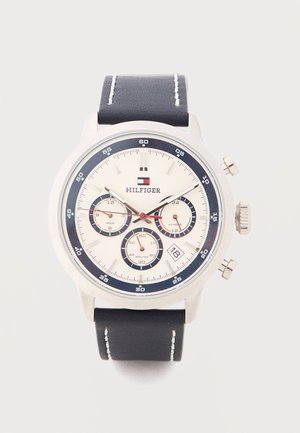 Tommy Hilfiger Armbanduhr mit schwarzem Lederarmband, silbernem Gehäuse, weißem Zifferblatt, drei Totalisatoren, Datumsanzeige und rotem Sekundenzeiger.