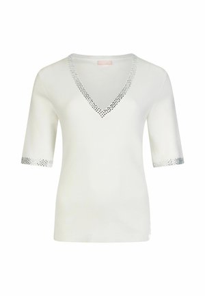 Bijela majica kratkih rukava s dubokim V-izrezom, ukrašena srebrnim detaljima duž vrata i rubova rukava. Mekana, glatka tkanina.