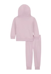Completo con felpa rosa chiaro e pantaloni abbinati, realizzato in tessuto morbido. Presenta un cappuccio, polsini e vita a coste, con una superficie liscia.