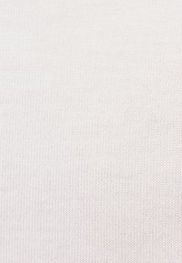 Weißer Strickstoff mit einem feinen, einheitlichen Stichmuster und weicher Textur.