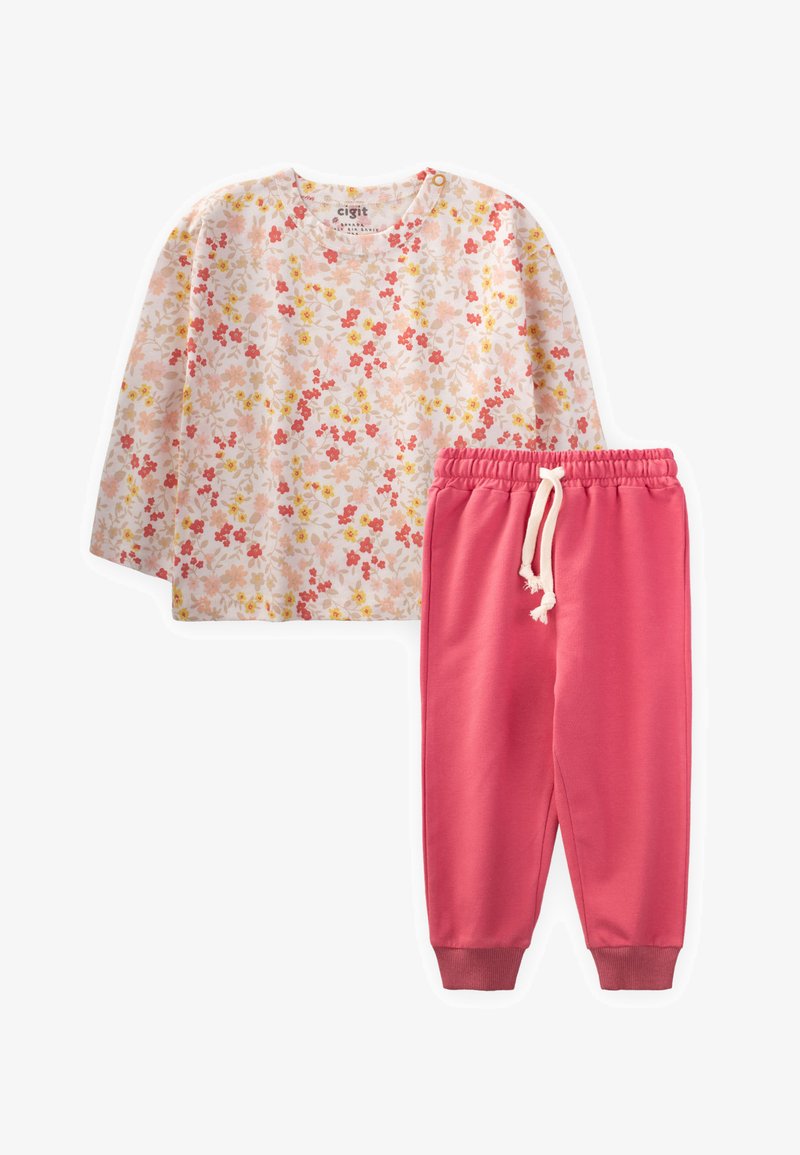 Blomstret langærmet skjorte i bløde nuancer af pink, rød og gul, parret med ensfarvede pink sweatpants med elastisk talje og snoretræk.