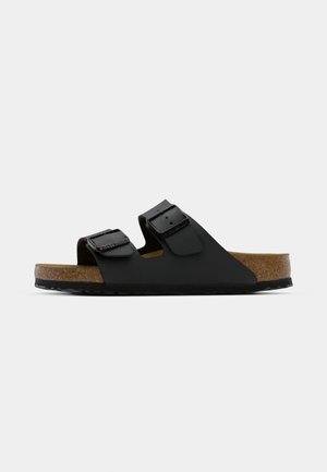 Black slide sandal made of synthetic material with two adjustable straps and metal buckles; cork footbed and textured rubber outsole.