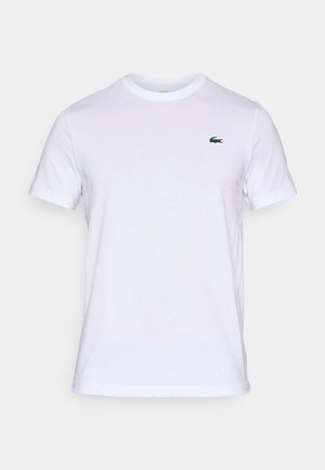 T-shirt bianco in cotone con maniche corte, caratterizzato da un piccolo logo del coccodrillo verde Lacoste sulla parte sinistra del petto. Collo giroclassico.