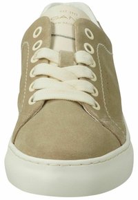 Beige suede sneakers with round toe, cream laces, and eyelets, featuring white rubber sole and subtle stitching detail on the sides.