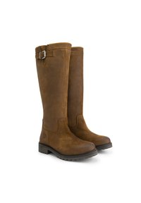 Paire de bottes hautes en suède marron avec des semelles noires épaisses et basses et une petite lanière à boucle près du haut sur fond blanc.