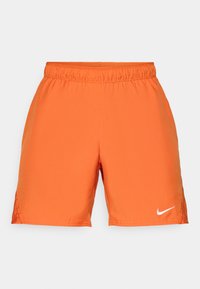 Oranžne atletske kratke hlače z elastičnim pasom. Narejene iz gladkega blaga, na spodnjem levem delu imajo bele Nike logotip.