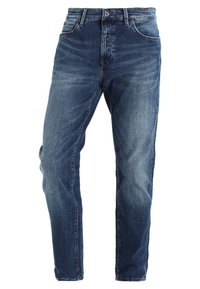 Tmavě modré džínové kalhoty s rovnými nohavicemi, zapínáním na zip a pěti kapsami. Povrch má mírné vyblednutí a detaily připomínající záhyby.