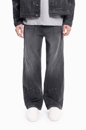 Melnas denim jaka ar teksturētu virsmu, kombinēta ar pelēkiem platām biksēm, kurām ir kontrastējoša šuve un ģeometriski raksti.