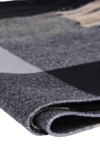 Coperta in feltro grigia con un motivo a scacchi. Texture morbida, con diverse tonalità di grigio e nero. Dettaglio del bordo arrotolato lungo il lato.