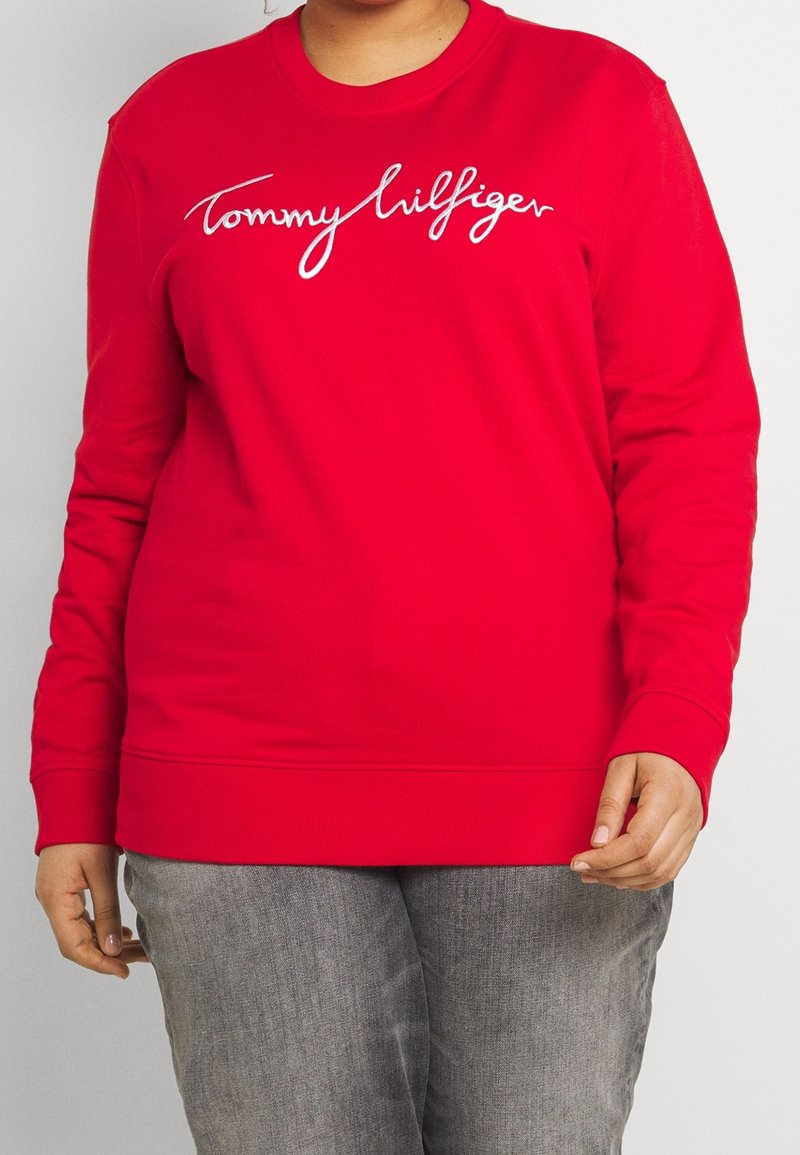 Rode sweatshirt met lange mouwen, ronde hals en geborduurd "Tommy Hilfiger" logo in het wit midden op de borst. Zachte stoftextuur.