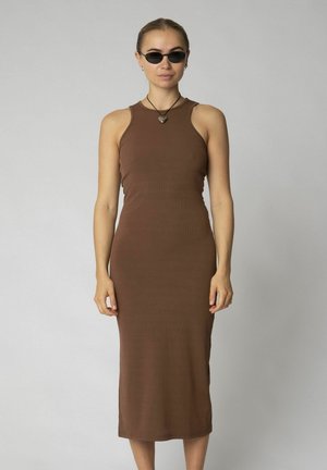Brown ribbed midi dress with a fitted silhouette, high neckline, and sleeveless design. Model wearing small black sunglasses and a necklace.
