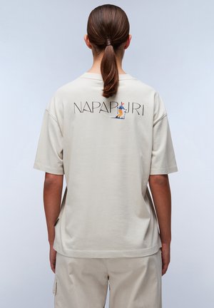 T-shirt in cotone beige con grafica logo sul retro raffigurante una figura che scia, maniche corte e vestibilità rilassata. Texture liscia, design semplice.