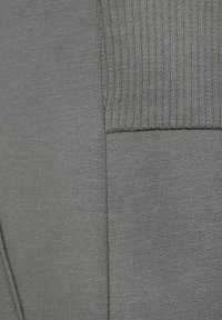 Graues Strickgewebe mit einem strukturierten Rippendesign, das einen glatten Abschnitt und kontrastierende Stiche für visuelles Interesse aufweist.