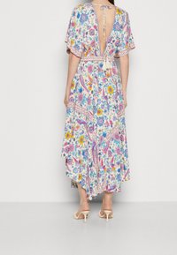 Blumengemustertes Kleid mit tiefem Rückenausschnitt und kurzen Ärmeln, mit taillierter Taille und charakteristischem Saum. Hergestellt aus leichtem Material.