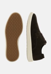 Brūni zamšaini sporta apavi ar krēmkrāsas gumijas zoles, ar auklu aizdari, iepresētu logotipu un teksturētu zoli, kas nodrošina saķeri.