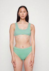 Conjunto de biquíni verde menta com top de decote redondo e cuecas de cintura alta, feito de tecido liso e elástico com design ajustado.