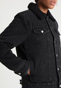 Zwarte denim jacket met een harige kraag, knoopsluiting, twee borstzakken en een casual fit. Gestructureerde stof met zichtbare stikseldetails.