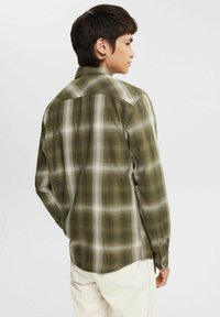 Green plaid long-sleeve shirt with button cuffs, featuring a mix of dark and light green tones, and a relaxed fit.