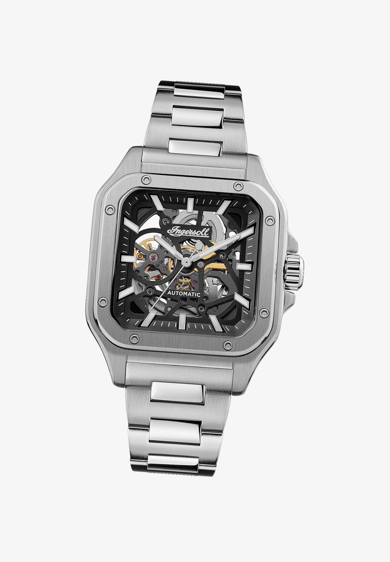 Zilveren roestvrijstalen automatisch horloge met vierkant zwart dial, transparante kast, grote uurmarkeringen en een metalen schakelarmband.