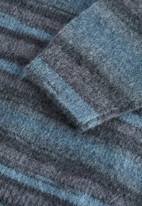 Blau- und grau gestreifter Strickstoff mit einer weichen Textur. Das Muster zeigt verschiedene Blautöne mit dunklen grauen Akzenten.
