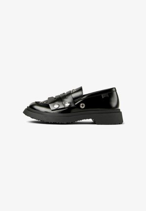 Mocassin en cuir noir brillant avec semelle en caoutchouc épaisse, détails à clous argentés, et une bride sur le dessus, présenté sur un fond blanc.
