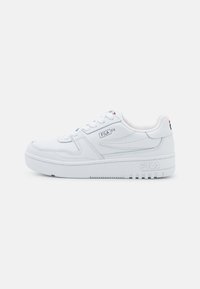 Sneaker bianco con tomaia sintetica liscia, design con lacci, colletto imbottito e suola in gomma testurizzata. Logo Fila visibile sul lato.