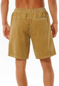 Braune Cordshorts mit einem strukturierten vertikalen Rippmuster, elastischem Bund und einer kleinen Gesäßtasche mit Reißverschluss.