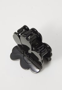 Črn plastični lasni sponka v obliki cveta, z visokim sijajem in več medsebojno povezanimi zobmi za oprijem in varen drž.