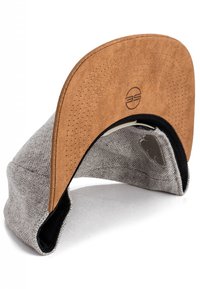 Grijze stofcap met een bruin leren rand. Heeft een gestikt ontwerp en een gladde binnenvoering. Gebogen vorm met zichtbare zwarte accenten.