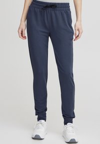 Mornarsko modre športne hlače v slim fit kroju, narejene iz mehke mešanice bombaža, z elastičnim pasom z vrvico in zapiranjem na gležnjih.