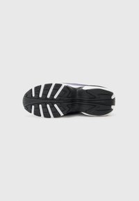 Black athletic shoe sole with a textured surface, featuring multidirectional lugs and white accents along the edges for traction.