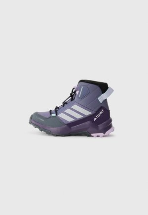 Botte de randonnée violette avec un dessus en synthétique texturé, accents noirs, capuchon gris et semelle extérieure violette. Présente trois rayures blanches et une languette à l'arrière.