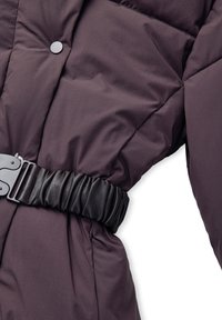 Chaqueta acolchada de color púrpura oscuro con un cinturón elástico negro y hebilla de metal, con un cierre de botones a presión en la parte delantera.