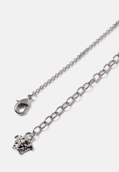 Corrente de metal prateada com uma mistura de elos pequenos e elos ovais maiores. Apresenta um encanto em forma de cabeça de bulldog e um fecho tipo lagosta.
