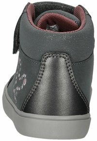 Zapatilla alta negra y gris con una cinta de velcro, parte superior de tela texturada, talón sintético liso y puntos decorativos en tonos rosas.
