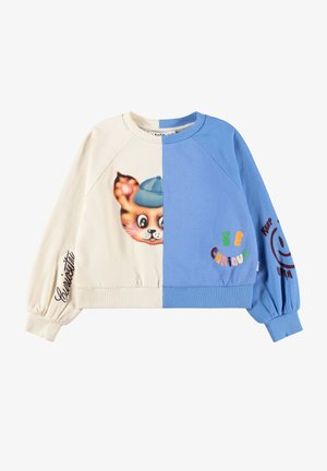 Bluza dresowa podzielona na kremową i niebieską, na przodzie twarz kota w niebieskiej czapce, na niebieskiej stronie napisy „Be Curious”, kursywą „Curiosity” i uśmiech na rękawach.