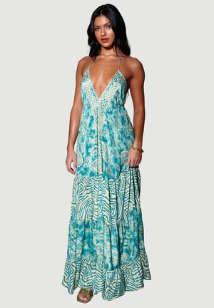 Robe longue couleur sarcelle avec un motif cachemire et rayures zébrées, dotée d'un décolleté en V profond, de fines bretelles et de volants à étages à l'ourlet.