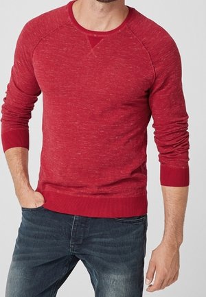 Roter Rundhalspullover mit strukturierter Oberfläche, gerippten Bündchen und Saum, der an den Schulter Nähten einen etwas dunkleren Akzent aufweist.