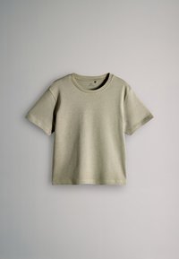 Lühikeste varrukatega beež puuvillane t-särk ümar kaelusega, esitletud laiali laotatuna helehallil taustal.