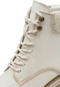 Bottes de cheville en cuir clair avec des lacets épais, œillets en métal et doublure en tissu texturé. Présente un bout rond et des accents cousus.