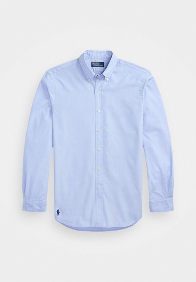 Šviesiai mėlyna ilgomis rankovėmis mygtukais užsegama marška su mygtukais prie apykaklės ir tamsiu siuvinėjimu apatinėje kairėje pusėje.