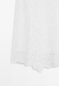 Weißes Spitzengewebe mit einem strukturierten, blumigen Muster; gewellte Kanten; leichtes und luftiges Design, geeignet zum Schichten oder für warmes Wetter.