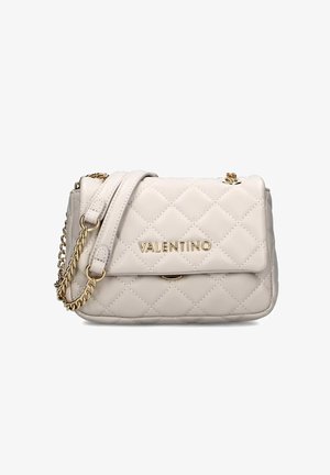 Borsa a tracolla in pelle beige trapuntata con logo dorato, chiusura a patta e tracolla a catena. Presenta una forma rettangolare e una texture morbida.