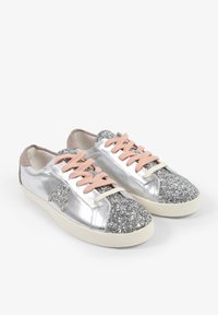 Zapatillas de cuero plateadas con punta brillante plateada, cordones rosas y acentos beige. Suela de goma plana. Textura notablemente brillante.