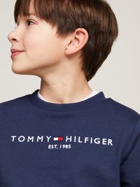 Navyblaues Sweatshirt aus weichem Baumwollmaterial mit geripptem Rundhalsausschnitt. Mit gesticktem Logo "TOMMY HILFIGER EST. 1985" in Weiß und Rot.