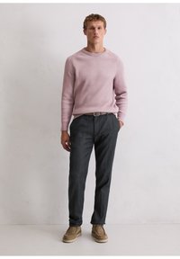 Light pink knit sweater with ribbed texture, paired with dark gray trousers and beige shoes. Simple design, casual fit, no visible patterns.