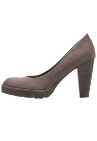 Zapato de tacón alto de ante gris con punta redonda, tacón grueso y suela de goma negra texturizada. Acentuado con un sutil ribete marrón alrededor de la base.