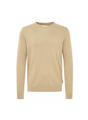 Svjetlucavo bež pleteni pulover s dugim rukavima, okruglim izrezom i glatkom teksturom. Sadrži suptilan uzorak i malu oznaku na rubu.