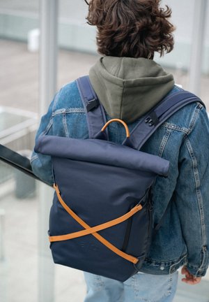 Navy Rolltop-Rucksack aus strapazierfähigem Material, ausgestattet mit orangefarbenen Riemen und einem kontrastierenden Reißverschluss, mit einem verstellbaren Design.